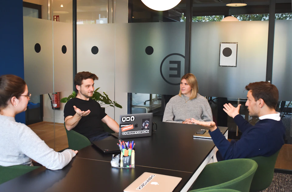 A small team meeting around a black table